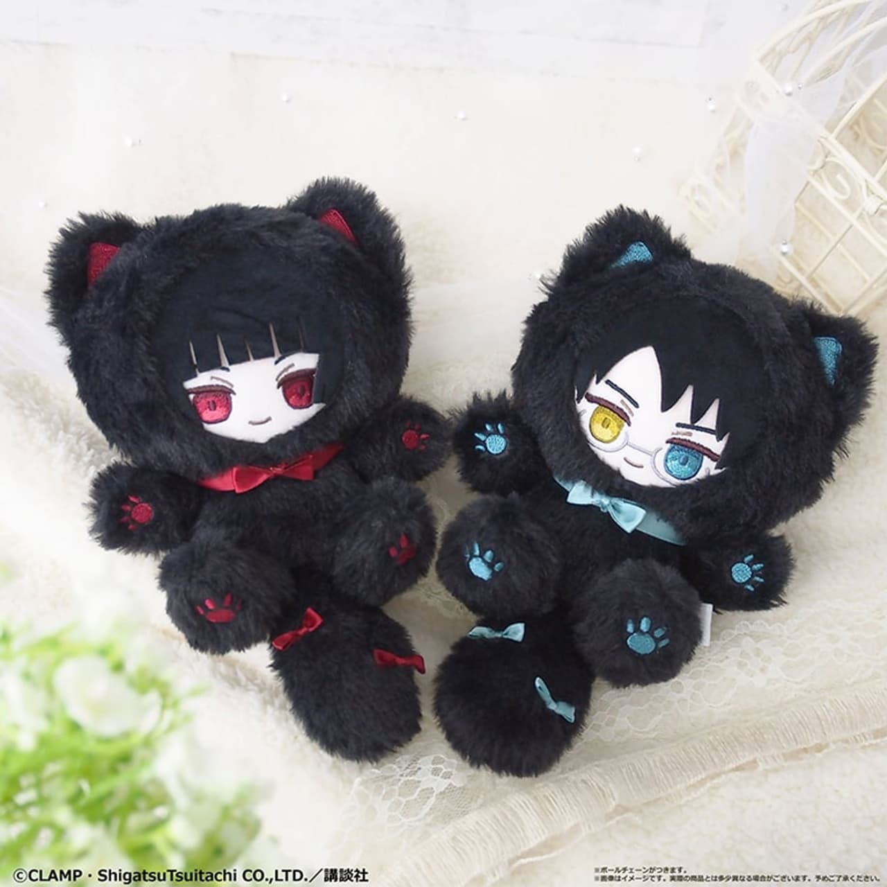 Se ven dos peluches de personajes con orejas de gato y ojos de diferentes colores.