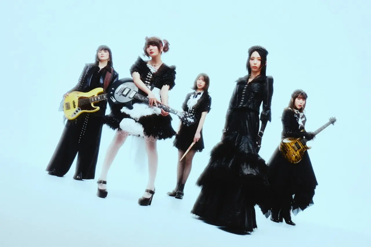 BAND-MAID posa con sus instrumentos vestida de negro y blanco.