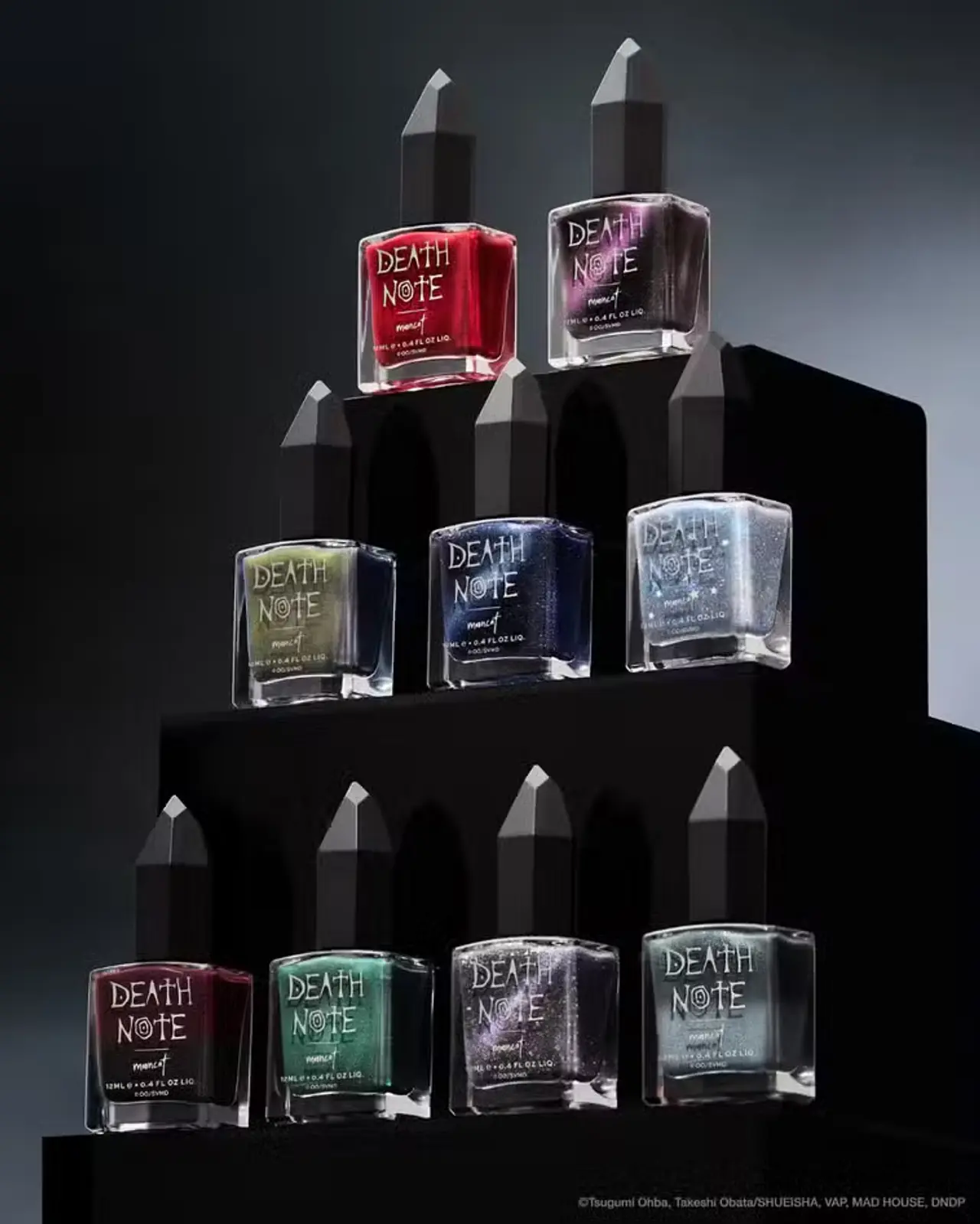 Frascos de esmalte de uñas inspirados en DEATH NOTE dispuestos en una pirámide.