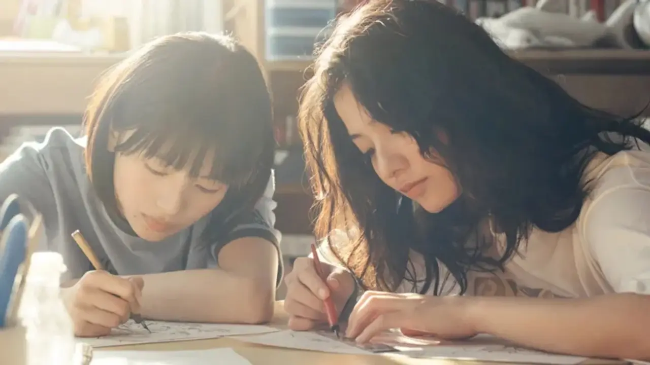 Dos chicas dibujando en un escritorio.