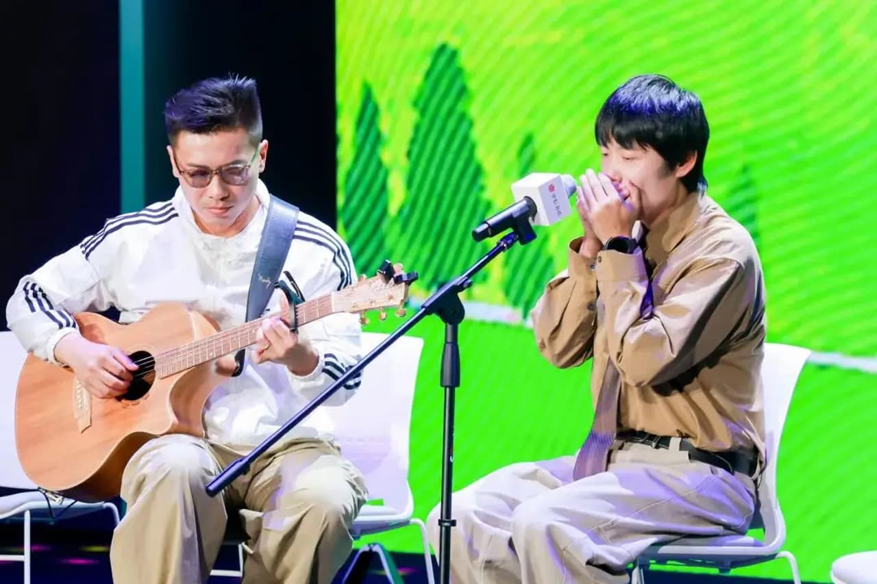 Dos personas en un escenario, una tocando la guitarra y la otra cantando.