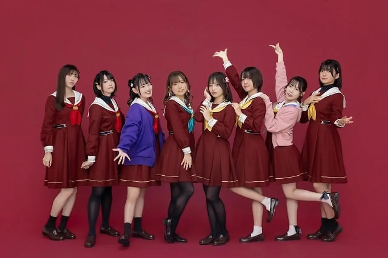Las ocho chicas del club posando frente a un fondo rojo.