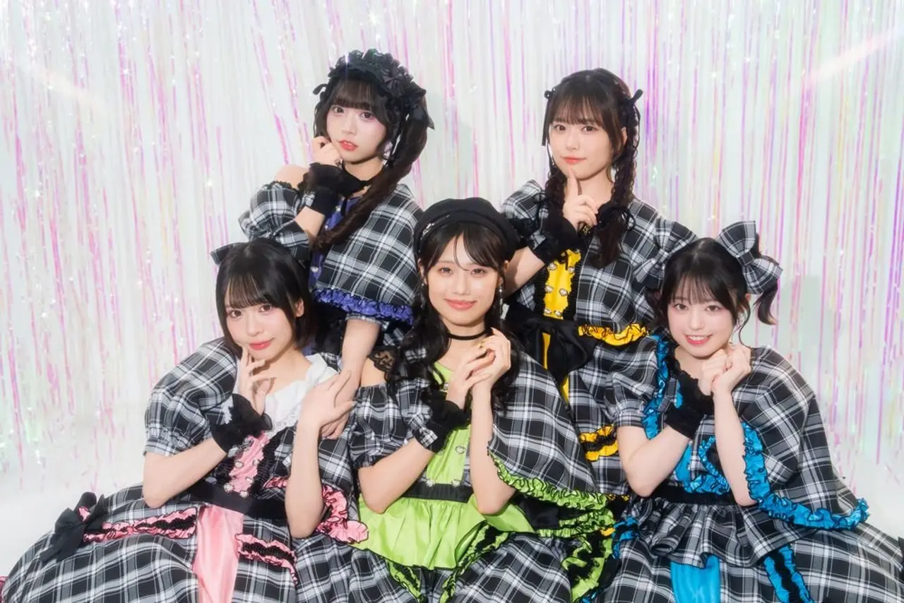 The group, gathered in front of a shiny decorative background.