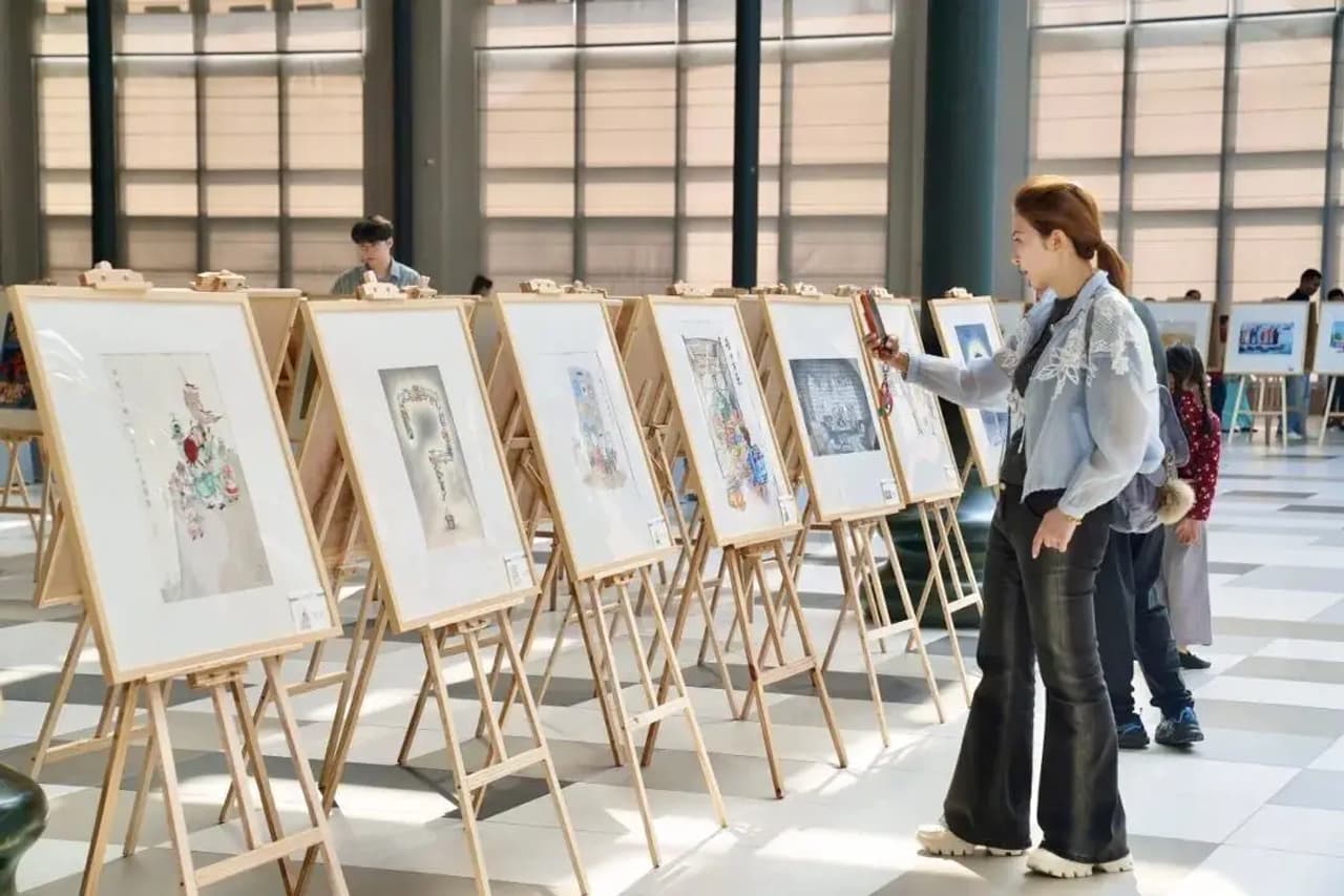 Una mujer observa obras de arte expuestas en un evento.