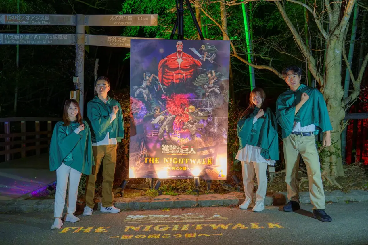 Visitantes posan frente a un cartel de 'Ataque a los Titanes' en el evento de colaboración.
