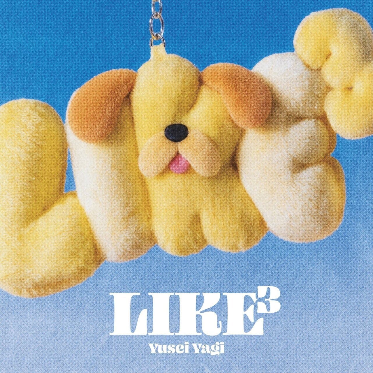Llavero de peluche en forma de perro amarillo con orejas marrones.